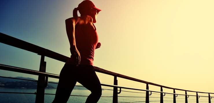 woman jogging on waterfront, sunny day
