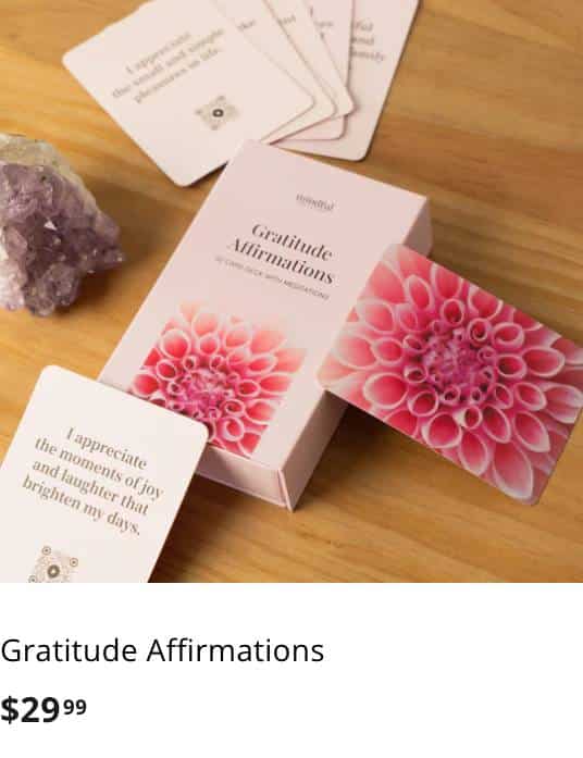 Gratitude Affirmations boxed card set displayed with a pink flower and amethyst crystal on a wooden surface.