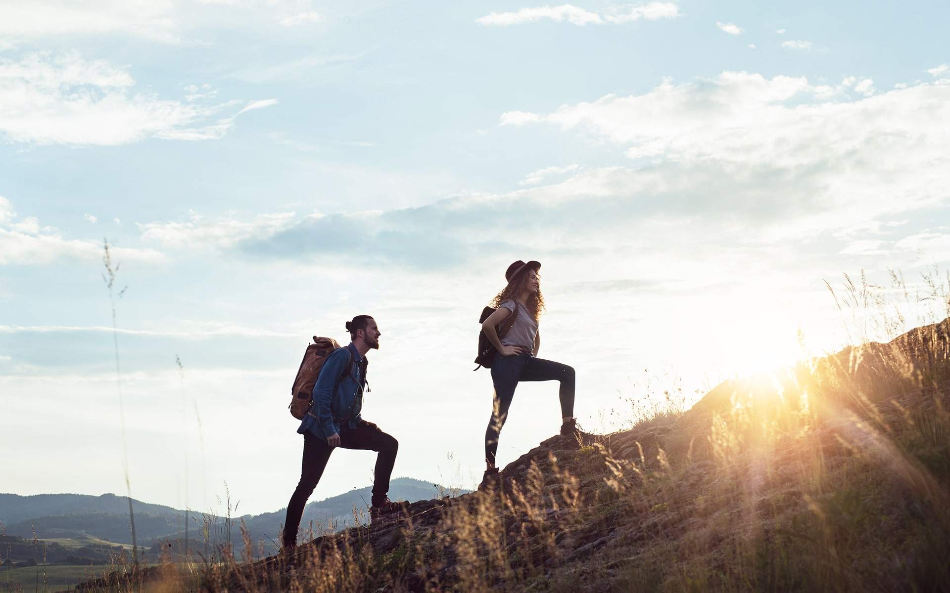 Young tourist couple travellers with backpacks hiking in nature.
