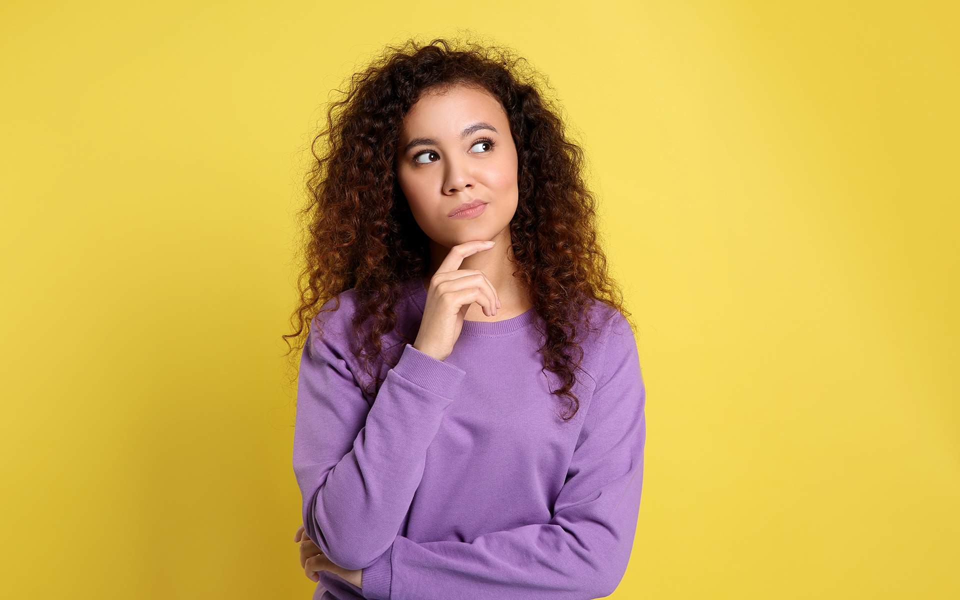 What pops into your mind when meditating? - Pensive Black woman on yellow background. Thinking about difficult question.